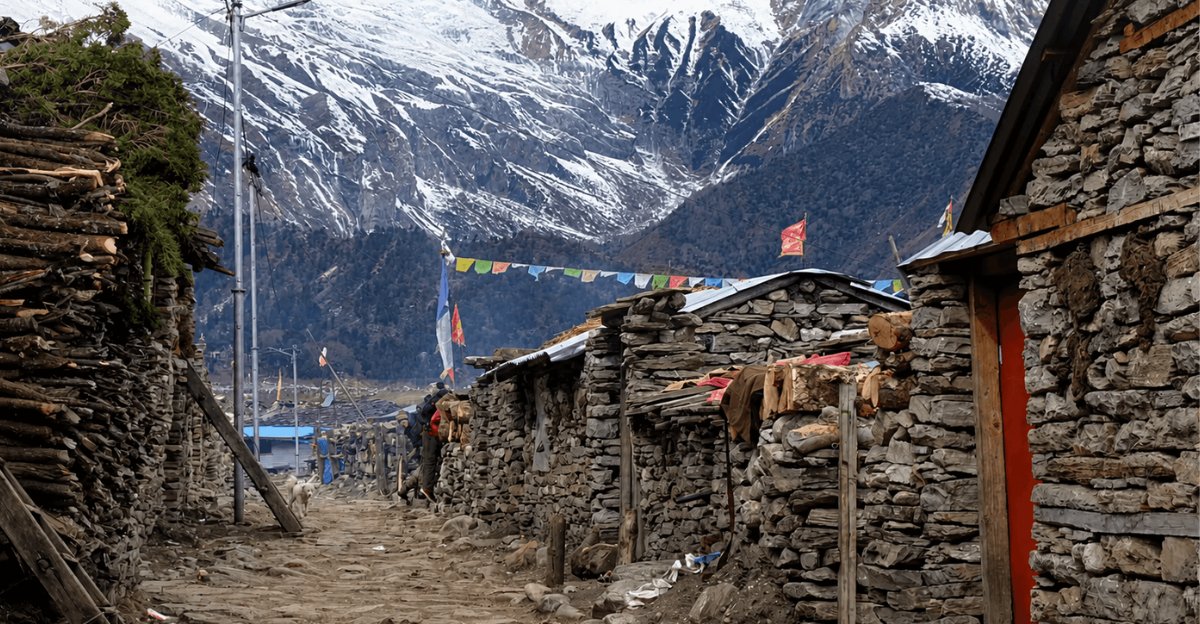A trekking trail winding past traditional stone-built houses in a remote Himalayan village