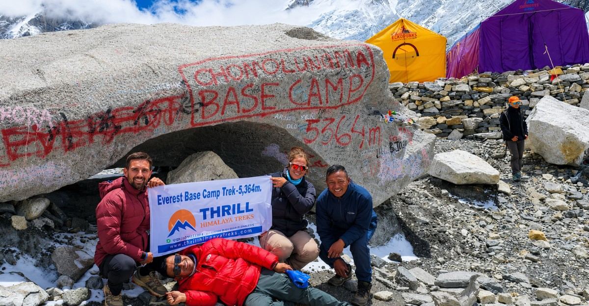 Hikers posing at the Everest Base Camp sign in the Himalayas
